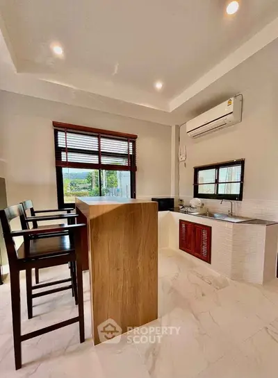 Modern kitchen with sleek design, featuring an open layout and stylish bar seating, perfect for entertaining.