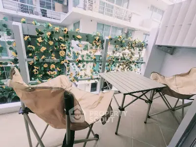 Charming balcony with cozy seating and floral decor, perfect for relaxation in a modern apartment.