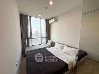 Modern bedroom with city view and large window, featuring cozy bedding and air conditioning.
