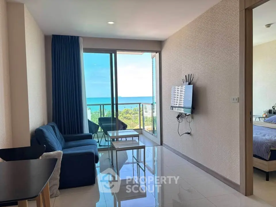 Modern living room with ocean view and sleek furnishings in a high-rise apartment.