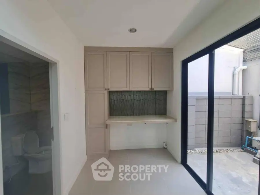 Modern interior with built-in storage and sliding glass door leading to outdoor space.
