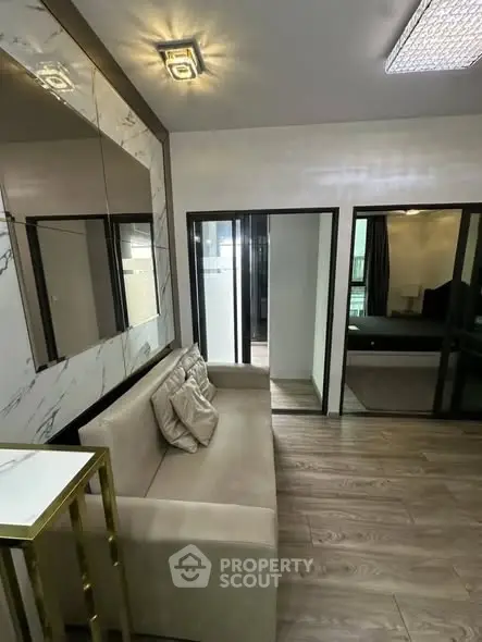 Modern living room with elegant decor and glass sliding doors leading to a bedroom.