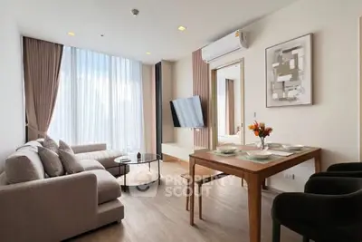 Modern living room with stylish decor, large window, and cozy seating area in a contemporary apartment.
