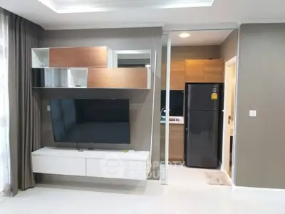 Modern living room with sleek TV unit and adjacent kitchen area