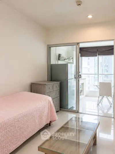 Modern studio apartment with glass partition, sleek furniture, and natural light.