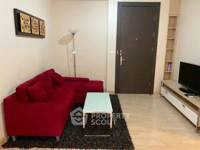 Cozy living room with red sofa, modern decor, and sleek TV setup.