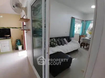 Cozy living room with modern decor and adjacent kitchen area in a bright home.