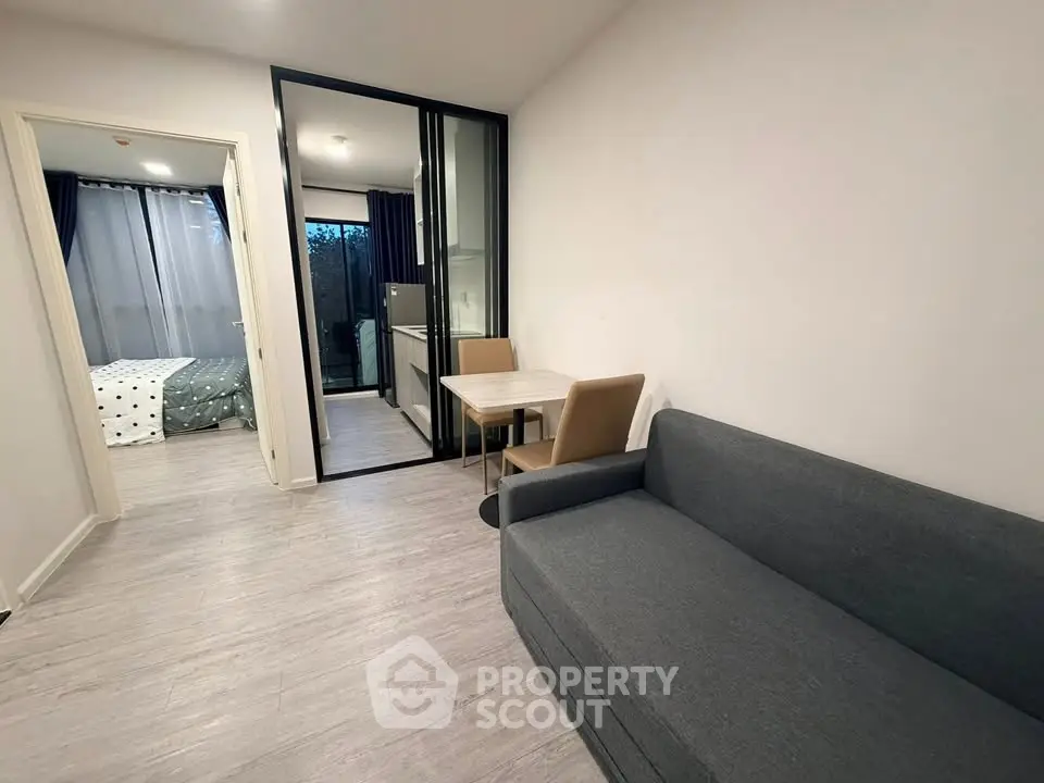 Modern apartment interior with cozy living room and view into bedroom, featuring sleek furniture and stylish decor.