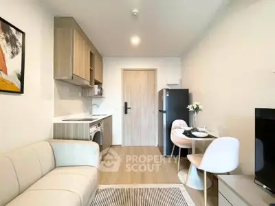 Modern living room with open kitchen, cozy seating, and dining area in stylish apartment.