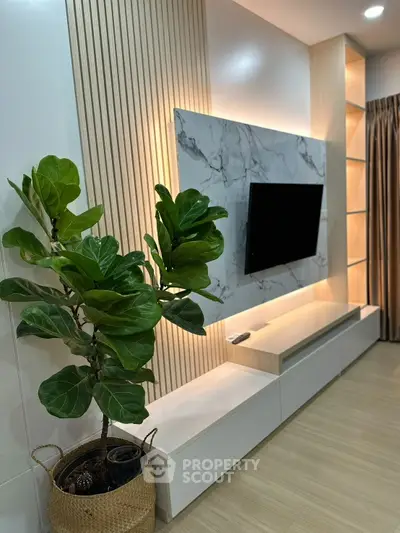 Stylish modern living room with TV, elegant wood paneling, and lush indoor plant.