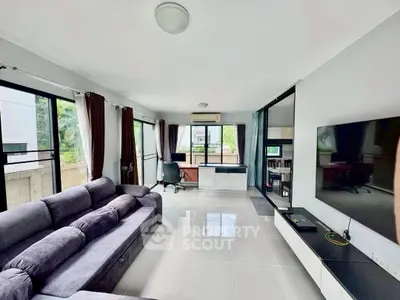 Spacious living room with modern decor and large windows offering natural light.