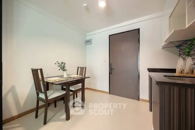 Modern dining area with elegant table and chairs next to a sleek kitchen setup.