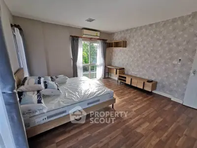 Spacious bedroom with modern decor and large window for natural light