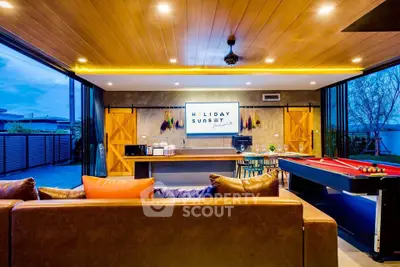 Luxurious open-plan living room with pool table and modern decor, perfect for entertainment.