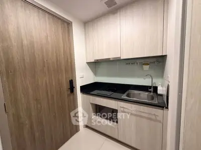 Modern compact kitchen with sleek cabinetry and integrated appliances in a stylish apartment.