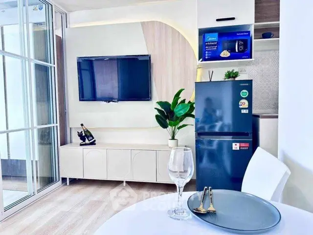 Modern living room with sleek TV setup and stylish decor in a contemporary apartment.