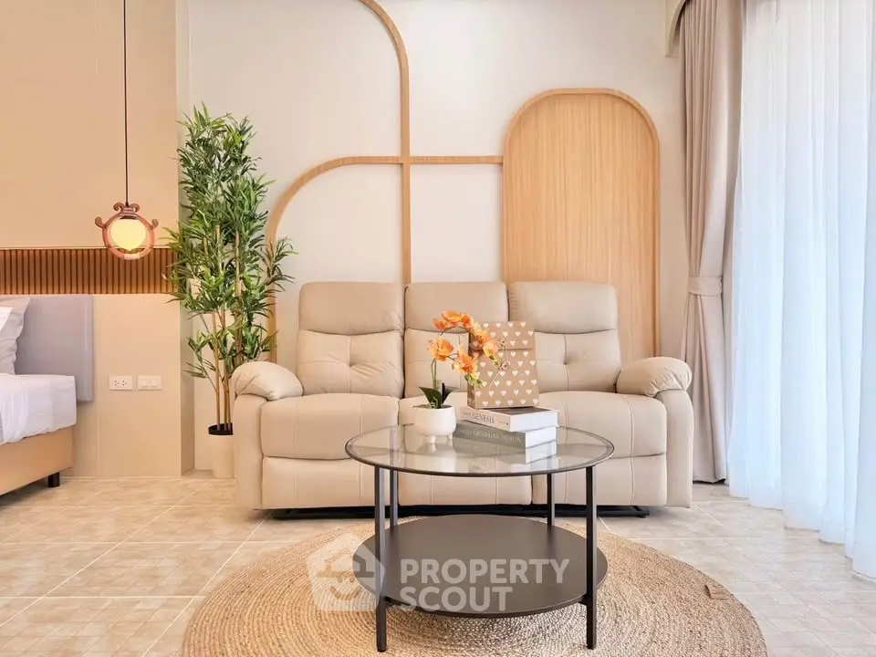 Modern living room with beige sofa, glass coffee table, and stylish decor