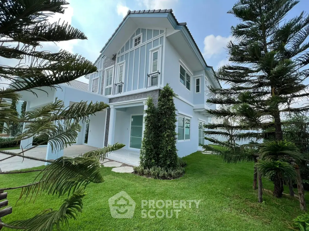 Charming two-story house with lush green garden and modern architecture.