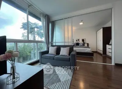 Modern living room with large windows and cozy bedroom view