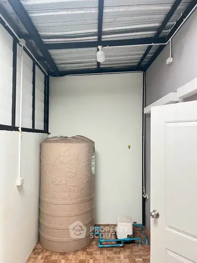 Utility room with water tank and plumbing in modern home