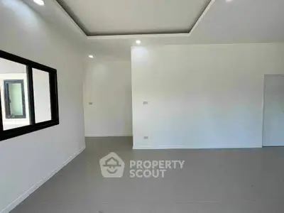 Spacious modern interior with sleek tile flooring and recessed lighting, perfect for customization.