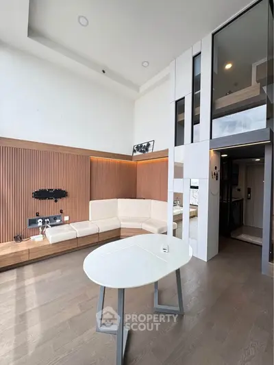 Modern living room with high ceiling and stylish decor in a contemporary apartment.