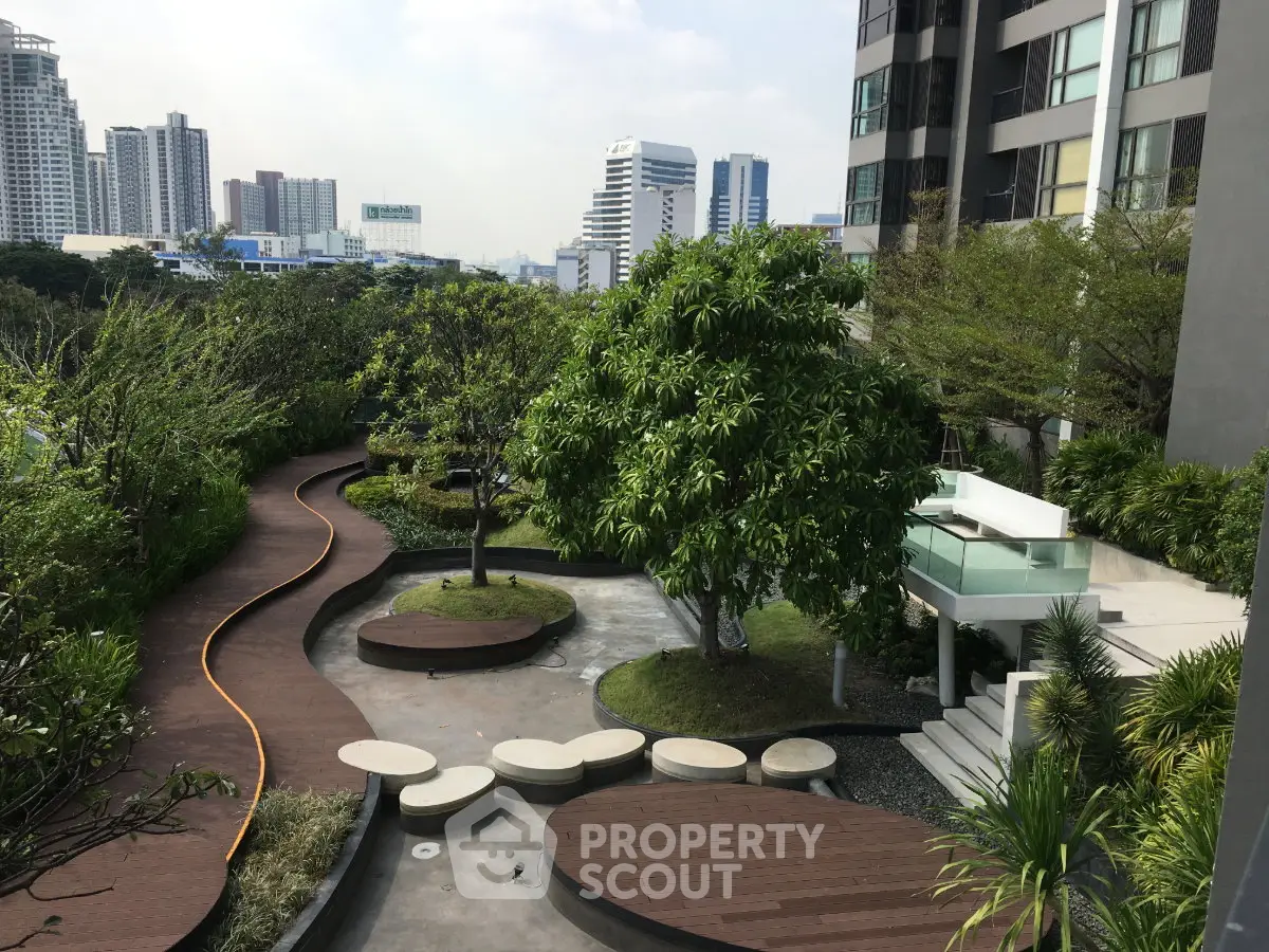 Stunning urban garden view with modern building backdrop, perfect for relaxation and leisure.