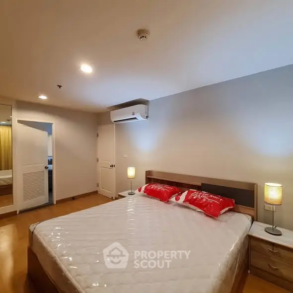 Spacious bedroom with modern decor and cozy lighting, featuring a comfortable bed and stylish furnishings.