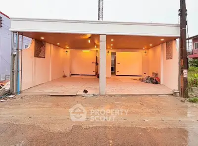 Spacious open garage with modern lighting and tiled flooring, perfect for multiple vehicles or storage.
