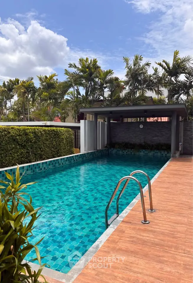 Luxurious outdoor pool with lush greenery and modern design, perfect for relaxation and leisure.