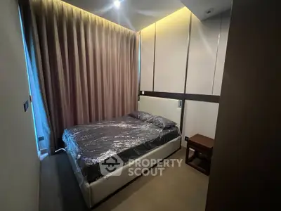 Modern bedroom with sleek design and ambient lighting, featuring a comfortable bed and stylish curtains.