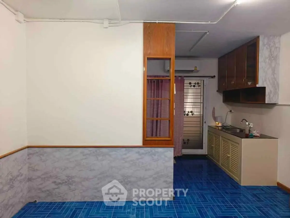 Charming kitchen with unique blue tile flooring and wooden cabinetry