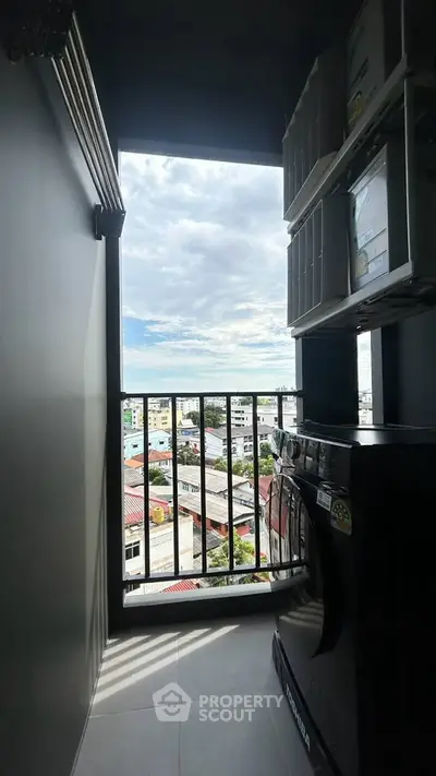 High-rise apartment balcony with city view and washing machine setup.