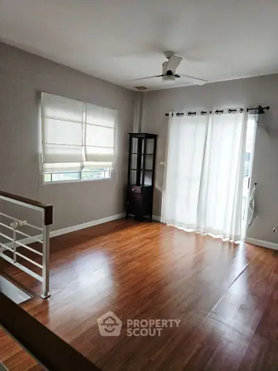 Spacious living room with wooden flooring and natural light