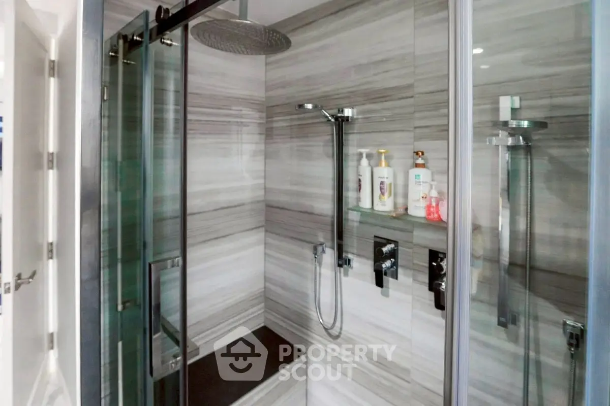 Luxurious modern bathroom with sleek glass shower and elegant tile design.
