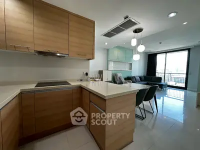 Modern open-layout kitchen and living room with sleek design and natural light.