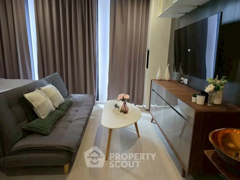 Modern living room with stylish sofa, sleek TV setup, and elegant decor.