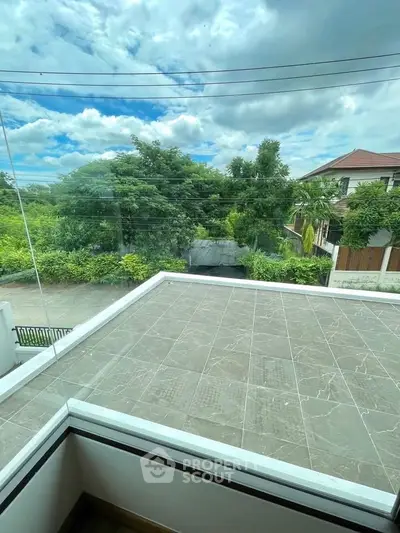 Spacious balcony with scenic view of lush greenery and modern architecture, perfect for relaxation.