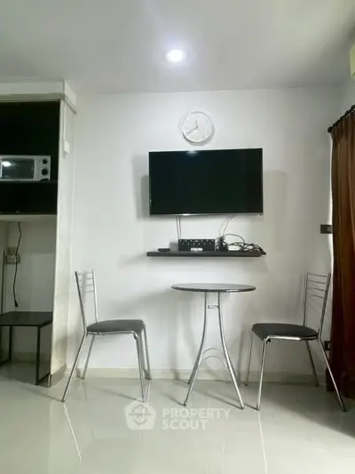 Modern minimalist living area with wall-mounted TV and sleek furniture.