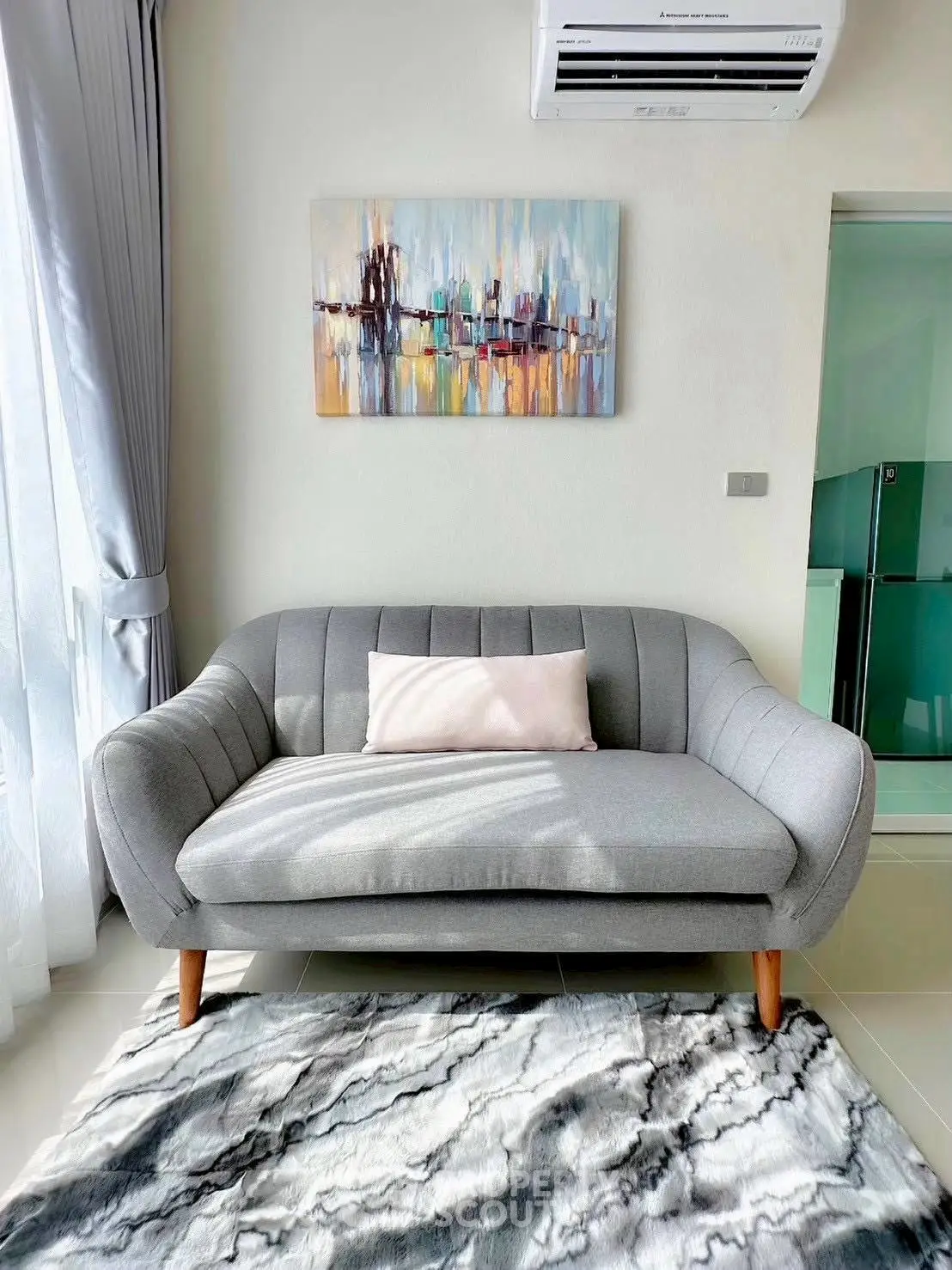 Stylish modern living room with cozy grey sofa and abstract art, perfect for relaxation.