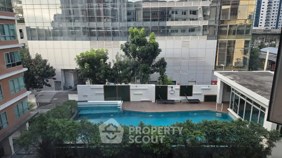 Modern apartment complex with a stylish swimming pool and lush greenery.