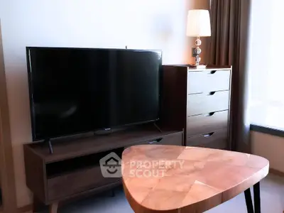 Modern living room with sleek TV stand, stylish lamp, and elegant wooden table.