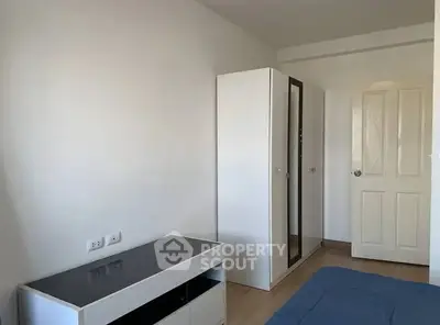 Minimalist bedroom with sleek wardrobe and modern furniture.