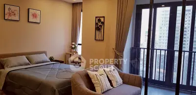 Spacious bedroom with balcony offering stunning city views in modern apartment.