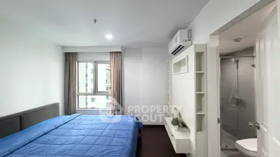 Modern bedroom with ensuite bathroom, featuring a large window and sleek design.