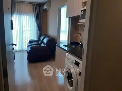 Modern living room with washing machine and sleek furniture, perfect for urban living.