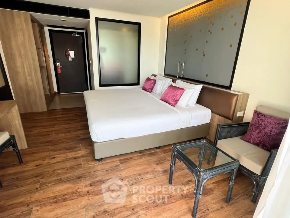 Spacious modern bedroom with wooden flooring and stylish decor