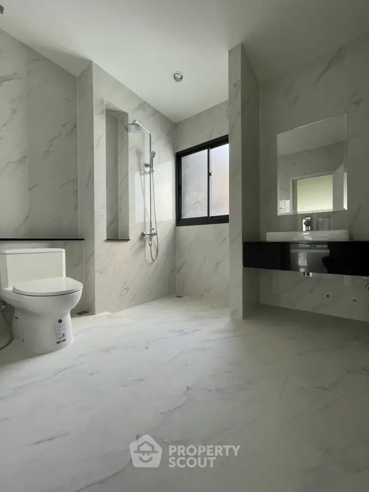 Modern bathroom with sleek design and large window for natural light.
