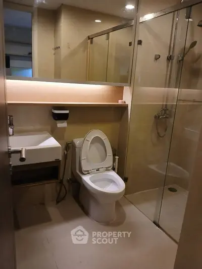 Modern bathroom with glass shower and sleek fixtures in a contemporary apartment.