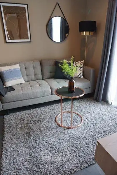 Stylish living room with modern decor, featuring a cozy sofa, chic round mirror, and elegant side table.